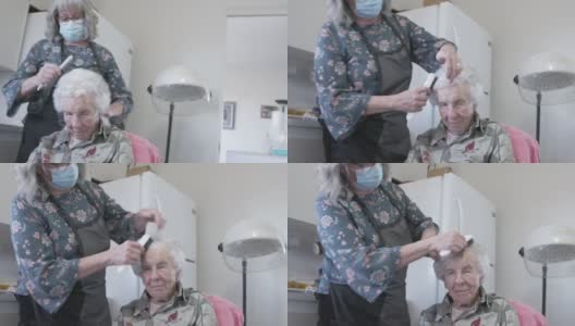 专业护理师在家洗发或烫发后给年长的白人妇女梳头高清在线视频素材下载