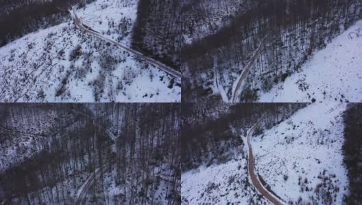 用无人机拍摄白雪覆盖的森林和乡村道路高清在线视频素材下载