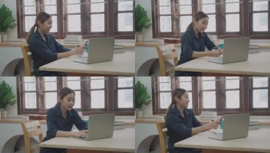 微笑的女商人使用笔记本电脑在公寓工作期间愉快的电话信息高清在线视频素材下载