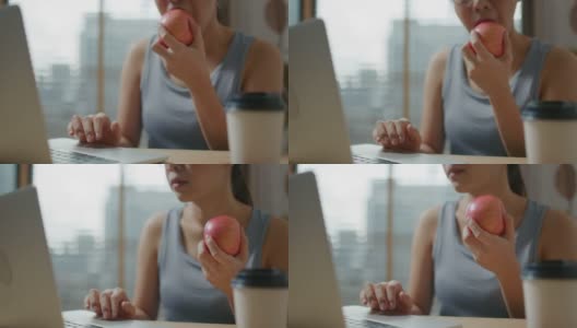 快乐的女人在家锻炼后吃一个苹果高清在线视频素材下载