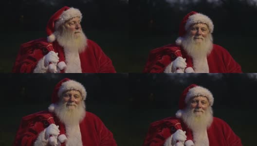 圣诞老人站在户外，手里拿着礼物高清在线视频素材下载