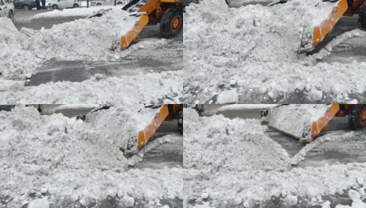 挖掘机，一辆汽车在清理城市街道上的积雪高清在线视频素材下载