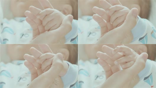 新生儿抱着母亲的手指的特写高清在线视频素材下载