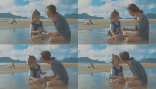 亚洲年轻的母亲和她的女儿和一只狗在海滩上玩耍高清在线视频素材下载