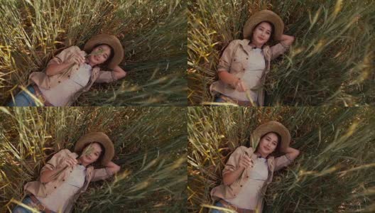 年轻的女农民躺在麦田里的小麦中休息高清在线视频素材下载