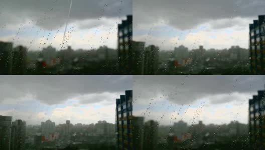 在暴风雨天，雨滴落在窗户上，城市天际线在背景中高清在线视频素材下载