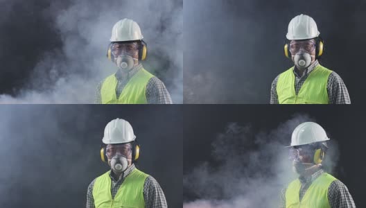 肖像亚洲工人戴着安全防护装备、护目镜、面罩、帽子、背心在危险的暗室吸烟高清在线视频素材下载