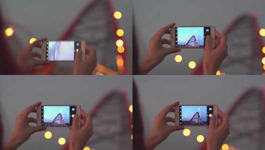 一名女子在日落时分用智能手机拍摄城市照片高清在线视频素材下载