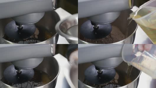 糖果商将油和水加入一个装满面粉的碗中，然后启动搅拌机高清在线视频素材下载