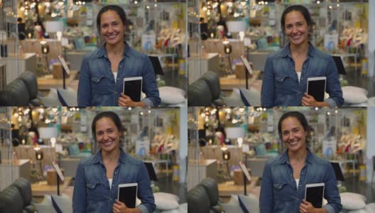 拉丁美洲女室内设计师在家具店拿着平板电脑，同时对着镜头微笑高清在线视频素材下载