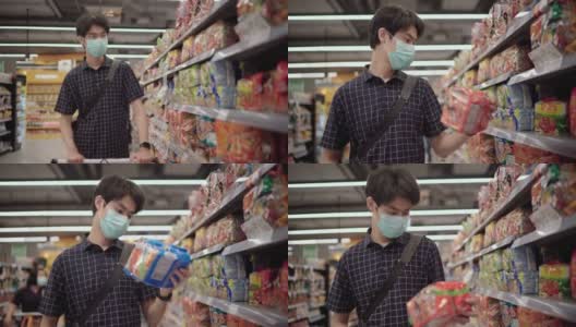一名亚洲男子在超市购物时戴上口罩高清在线视频素材下载