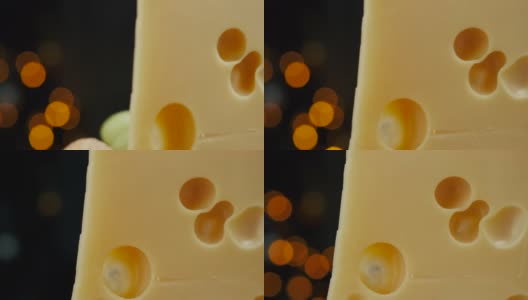 靠近中等硬的奶酪头的一部分，伊达豪达干酪帕尔马干酪放在木板上，坚果和葡萄在盘子上旋转高清在线视频素材下载