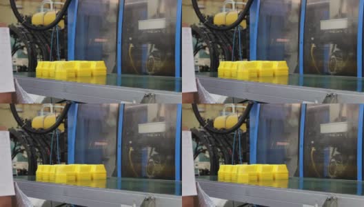工厂机器放置黄色塑料容器在传送带上高清在线视频素材下载