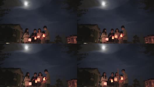 亚洲华人妈妈带着孩子和侄子拿着纸灯笼，庆祝中秋节。高清在线视频素材下载