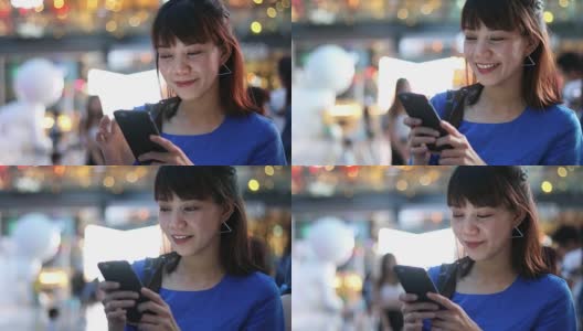 一名中国妇女在夜城的街道上使用手机高清在线视频素材下载