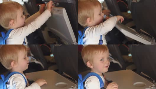 小男孩在飞机上把桌子放低了。高清在线视频素材下载