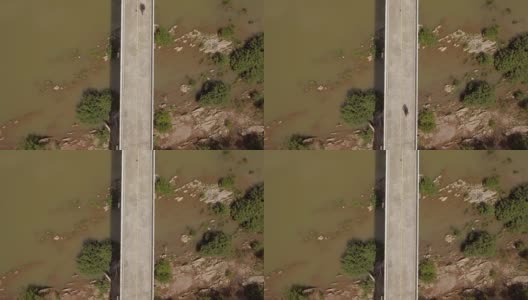 航拍冒险摩托车骑在横跨泰国南省南河的一座桥上俯视图高清在线视频素材下载
