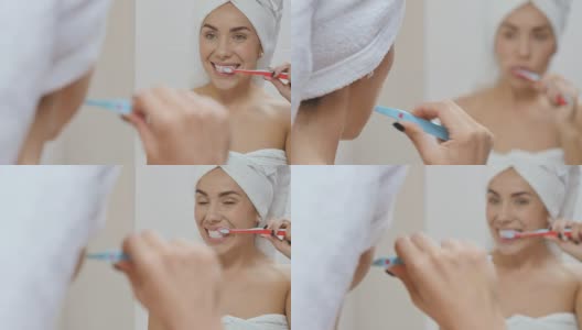 一个头裹毛巾的漂亮女人在浴室的镜子前刷牙高清在线视频素材下载