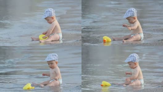 小婴儿坐在海边，他的玩具被海浪带走了高清在线视频素材下载