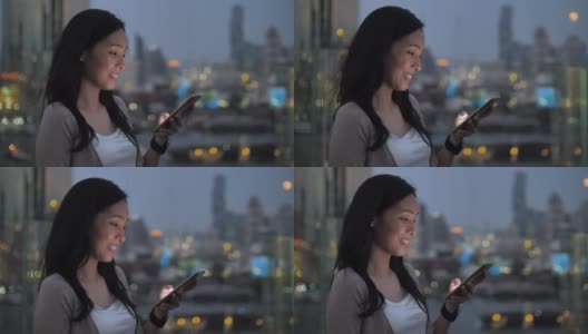 亚洲女人使用智能手机在城市晚上美丽的散景高清在线视频素材下载
