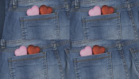 全景。两个象征性的心形从牛仔裤后口袋里伸出来，特写。情人节。高清在线视频素材下载
