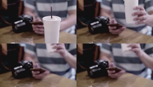 摄影师用智能手机喝冰拿铁高清在线视频素材下载