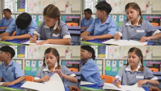 澳大利亚土著女学生穿着格子裙在课桌上写课本高清在线视频素材下载