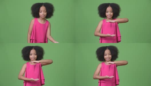 年轻可爱的非洲女孩与非洲式头发显示一些东西高清在线视频素材下载