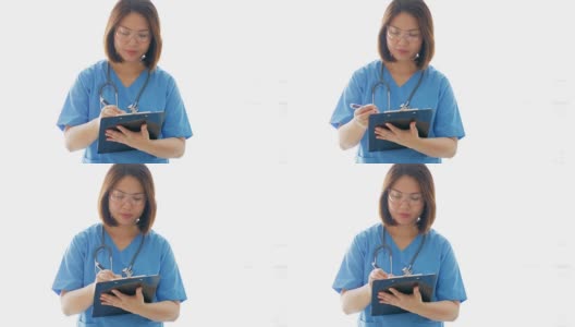 女医生用蓝色制服在写字板上写字高清在线视频素材下载