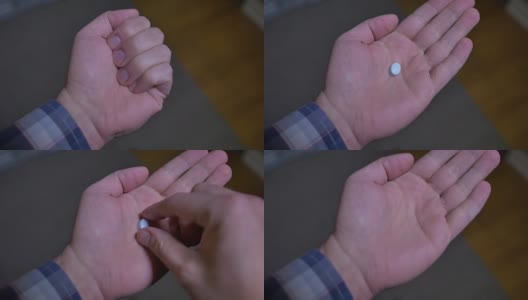 一只手打开，另一只手拿着蓝色小药丸高清在线视频素材下载