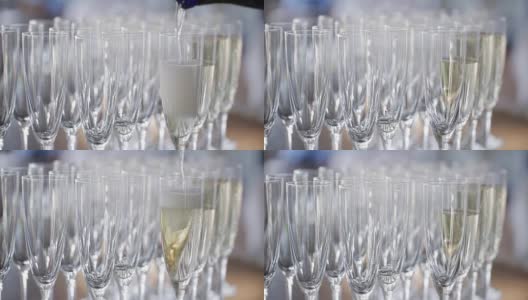 在庆祝活动中，优雅的玻璃杯和香槟酒排成一排摆放在餐桌上。服务员倒香槟高清在线视频素材下载