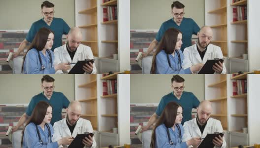 医疗队正在医院办公室讨论x光。3人医生和护士全高清高清在线视频素材下载