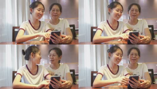 亚洲家庭年轻的青少年和母亲度假放松使用数字平板电脑和智能手机在家里做作业，放松与在线游戏和在社交网络上的短信高清在线视频素材下载