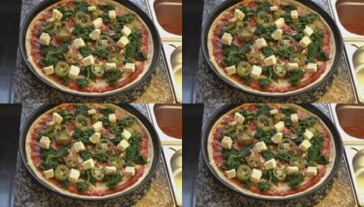 一个有菠菜，羊乳酪和墨西哥辣椒的披萨的特写高清在线视频素材下载