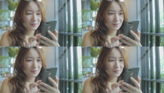 一名在咖啡店使用智能手机的亚洲女性高清在线视频素材下载