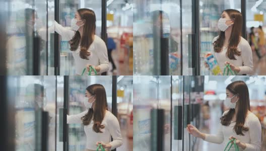女人戴着口罩在超市购买冷冻产品高清在线视频素材下载