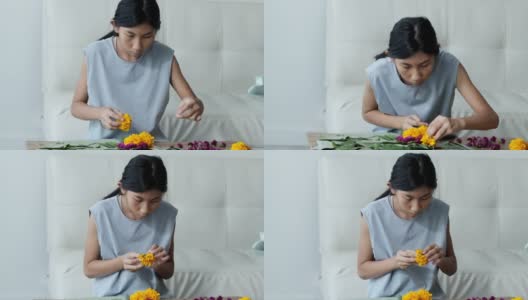 快乐的亚洲女孩花插花(由香蕉叶和花漂浮在河里祈祷和感谢你)一起在家，为晚上的时间做准备。高清在线视频素材下载