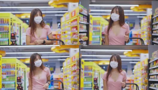 亚洲妇女戴着口罩，拿着购物篮在超市购物。在冠状病毒危机或新冠肺炎爆发期间，女孩在货架上挑选、寻找食物。高清在线视频素材下载