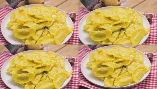 Tartollini奶酪和肉在盘子里倒碎意大利干酪和橄榄油。意大利艾米利亚罗马涅地区的传统菜肴。自制的意大利面。意大利美食高清在线视频素材下载