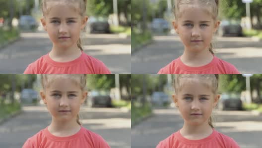 肖像小女孩看着相机站在街道上的城市在夏天的一天。年轻的认真思考好奇的孩子看镜头的特写户外。脸，眼睛，严肃沉思的孩子。高清在线视频素材下载
