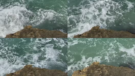 岩石海岸上的海浪。暴风雨的海景。蓝绿色海水表面。高清在线视频素材下载