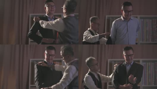 亚洲华人成熟男子裁缝与脸胡茬帮助他的客户试穿新的定制西装高清在线视频素材下载