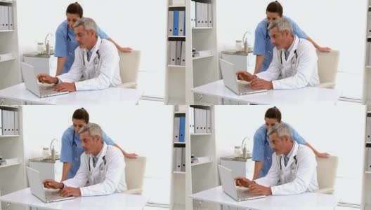 慢动作医生在桌子上使用电脑键盘高清在线视频素材下载