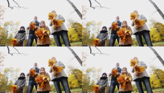 快乐的一家人在公园里玩着秋叶高清在线视频素材下载