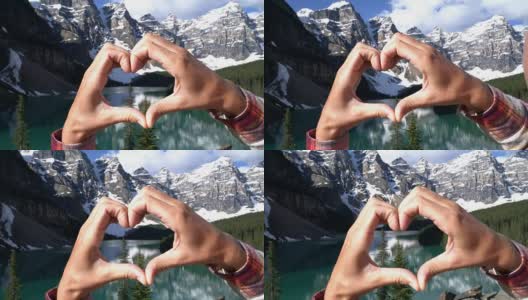近距离的手使心形框架上的山湖景观高清在线视频素材下载