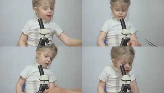 一个男孩和一个小女孩正在显微镜下接受检查。高清在线视频素材下载