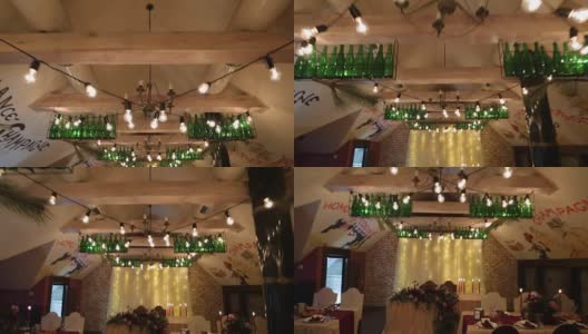 圣诞婚礼宴会厅内部装饰和餐桌设置的广角拍摄。冬季装饰的球根花环，蜡烛，鲜花，球果和冷杉树枝高清在线视频素材下载