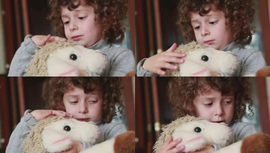 孩子抚摸着玩具羔羊高清在线视频素材下载