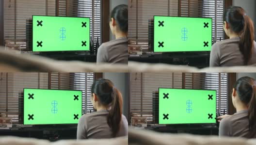 在家里看绿屏幕电视的女人高清在线视频素材下载