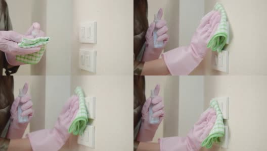 恐慌的亚洲妇女戴着手套喷洒酒精清洁灯开关和门把手，以防止冠状病毒。高清在线视频素材下载